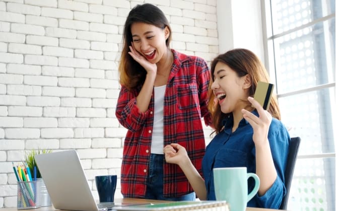 Two People Excited in Front of a Laptop